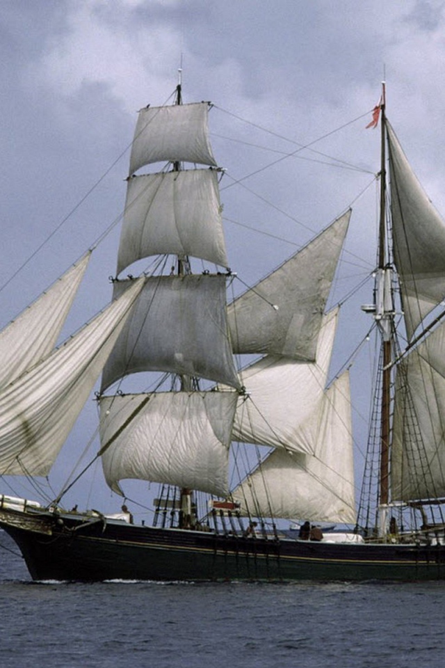 Корабль с белыми парусами в море 