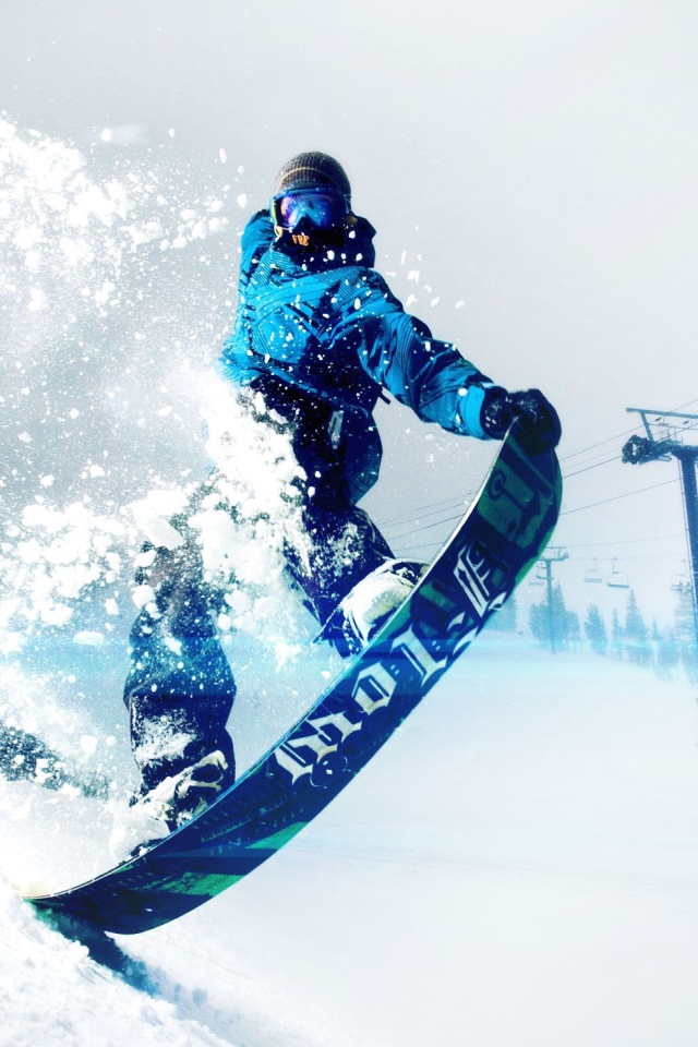 Спортсмен сноубордист на заснеженном склоне горы 