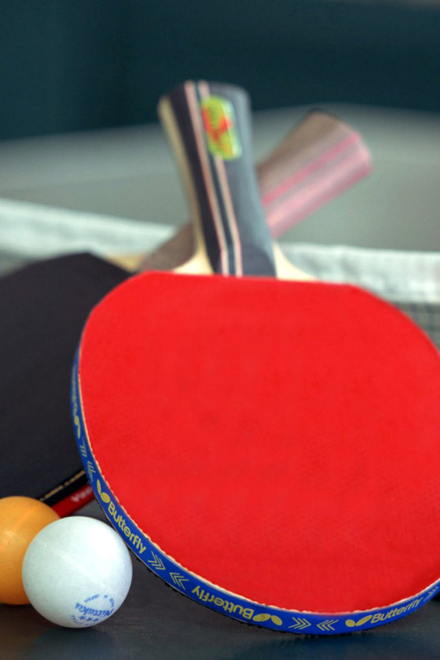 Ракетки для настольного тенниса и мячи на столе  