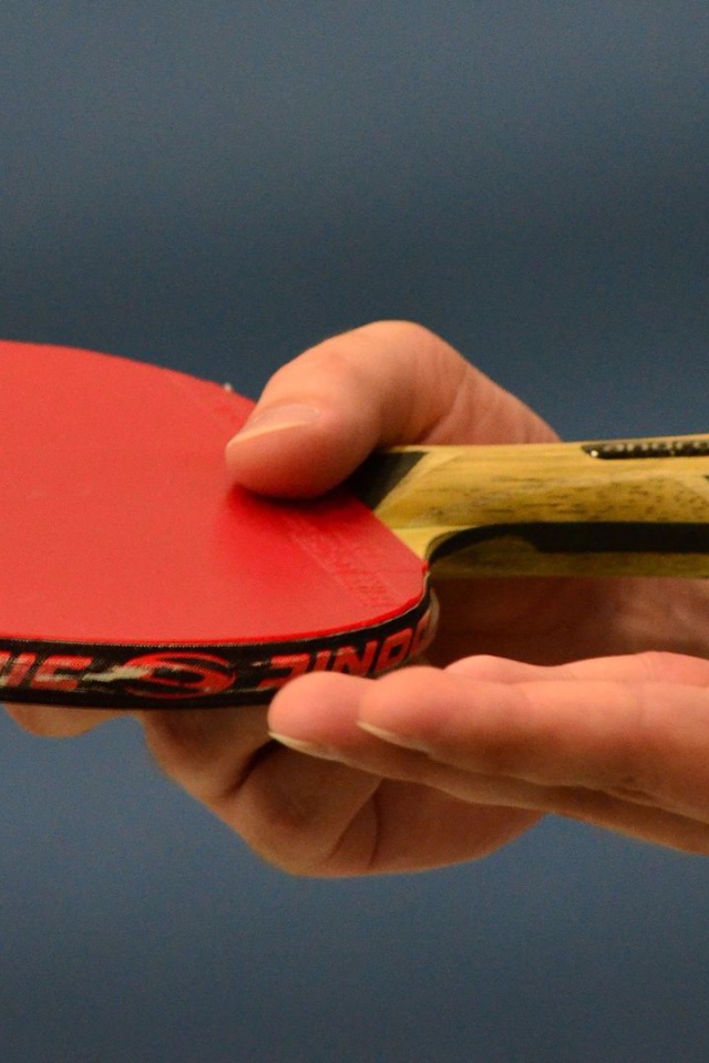 Ракетка для настольного тенниса и мяч в руке 