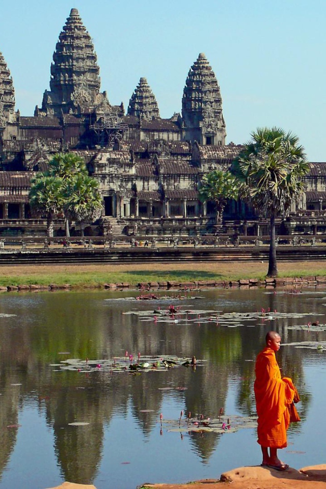 Монахи на берегу водоема у храмового комплекса Ангкор Ват 