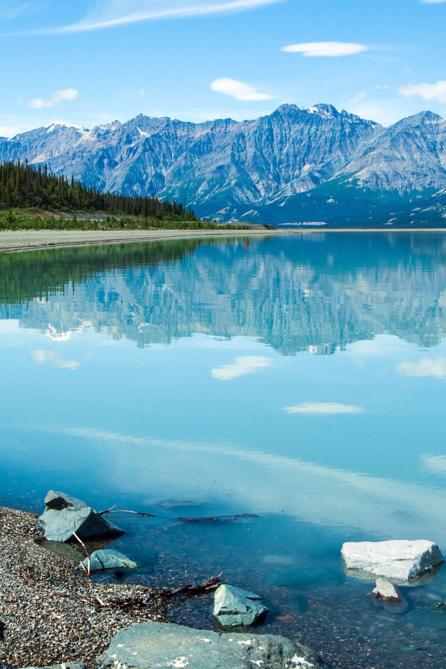 Горы отражаются в голубой воде озера Клуэйн, Национальный парк на территории Юкон, Канада.