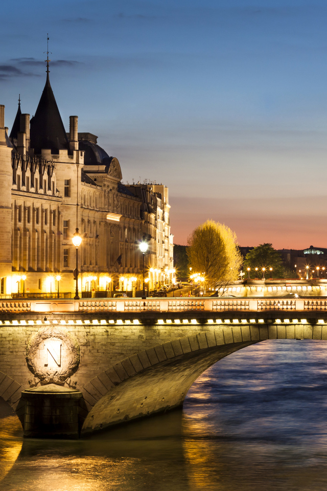 The bridge in the light of the night lights at the former royal castle Conciergerie, Paris. France