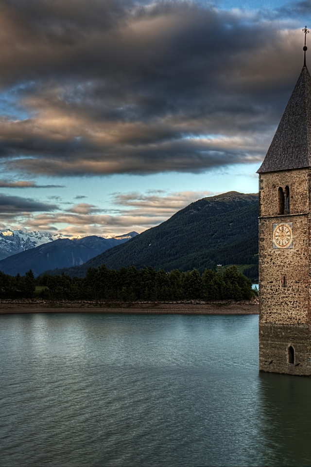 Старинная часовня на фоне красивого неба посреди озера Резия, Италия