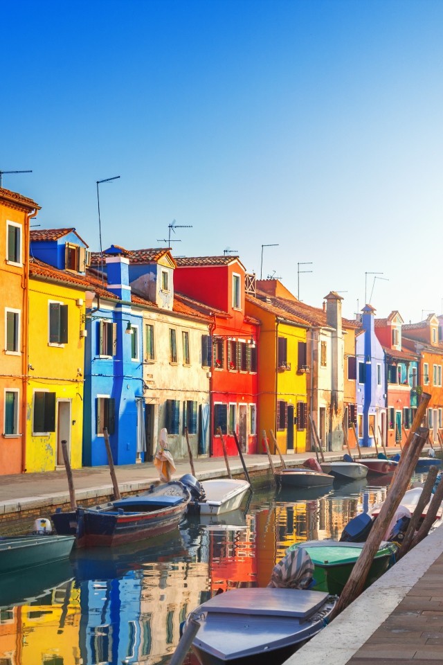 Multi-colored houses by the water channel with boats, Italy