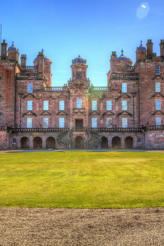 Замок Drumlanrig Castle с зеленым  газоном, Шотландия 