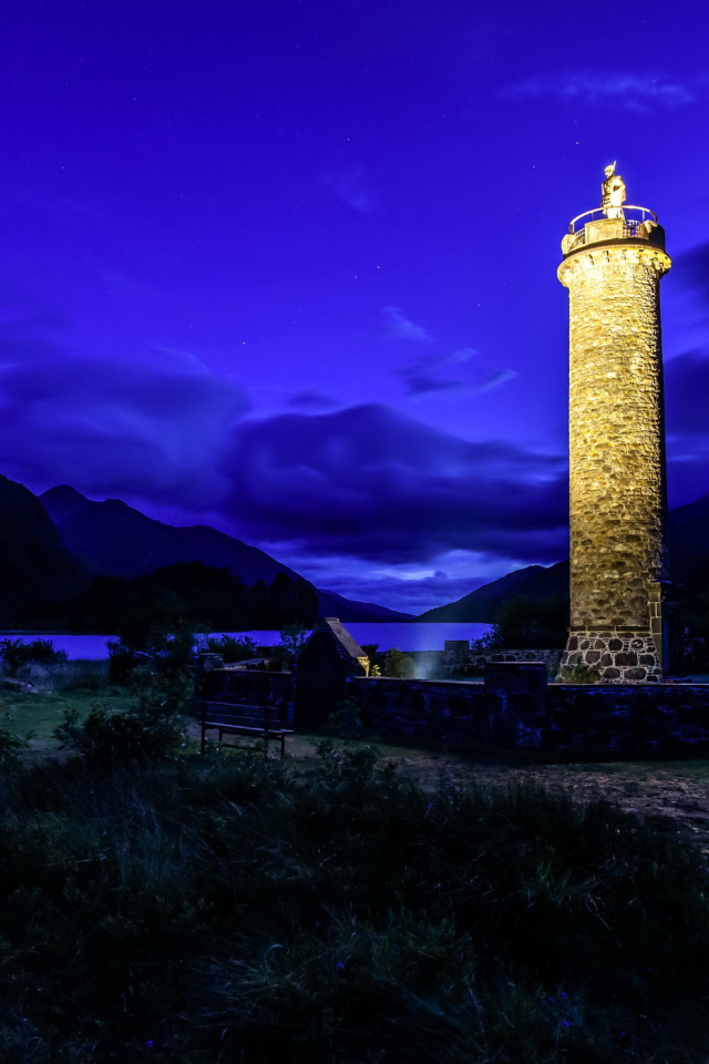Ночной маяк у побережья на фоне гор, деревня Гленфиннан. Шотландия
