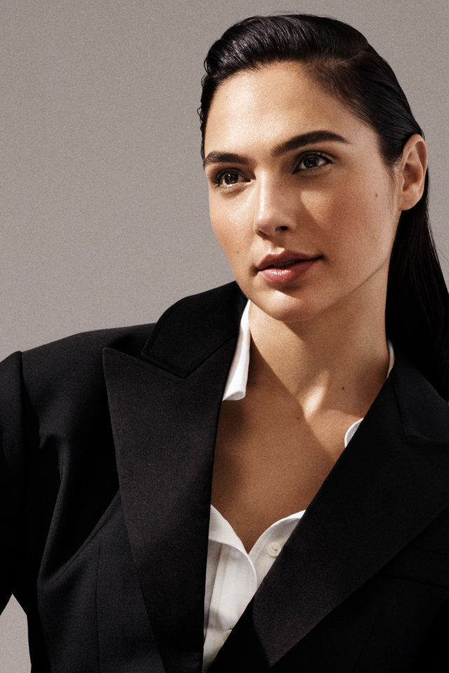 Актриса Галь Гадот в черном пальто на сером фоне