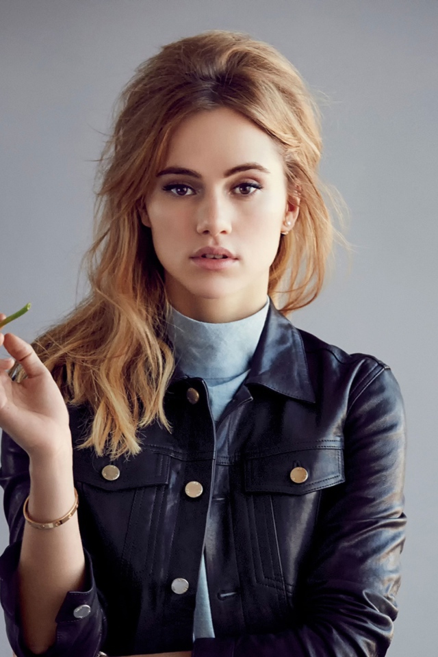 Актриса Сьюки Уотерхаус с цветком в руках на сером фоне