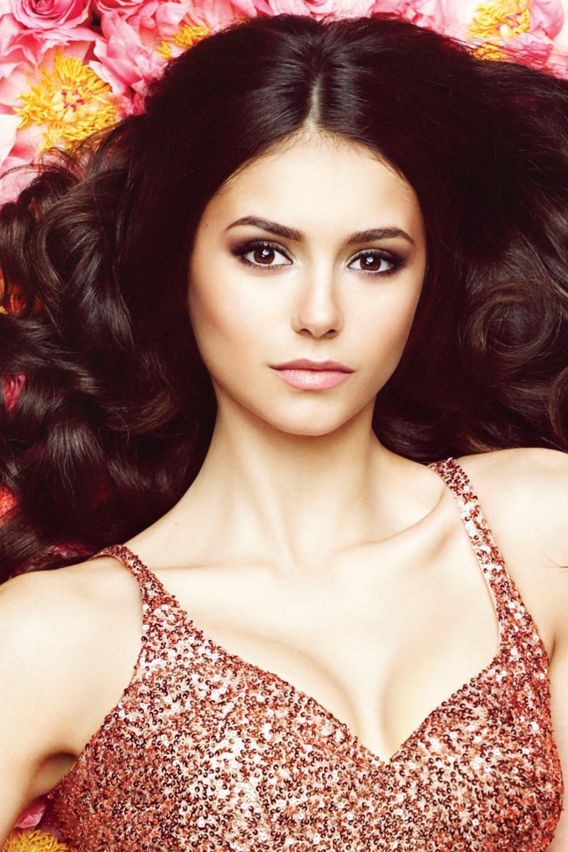 Красивая брюнетка, актриса Нина Добрев лежит на цветах