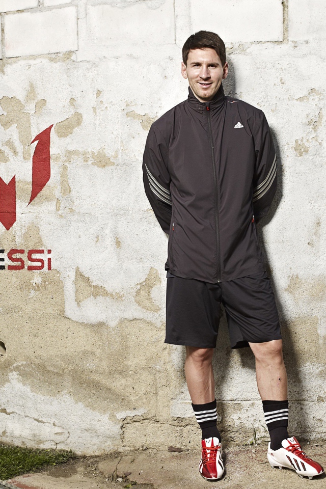 Футболист Лионель Месси позирует  на фоне стены 