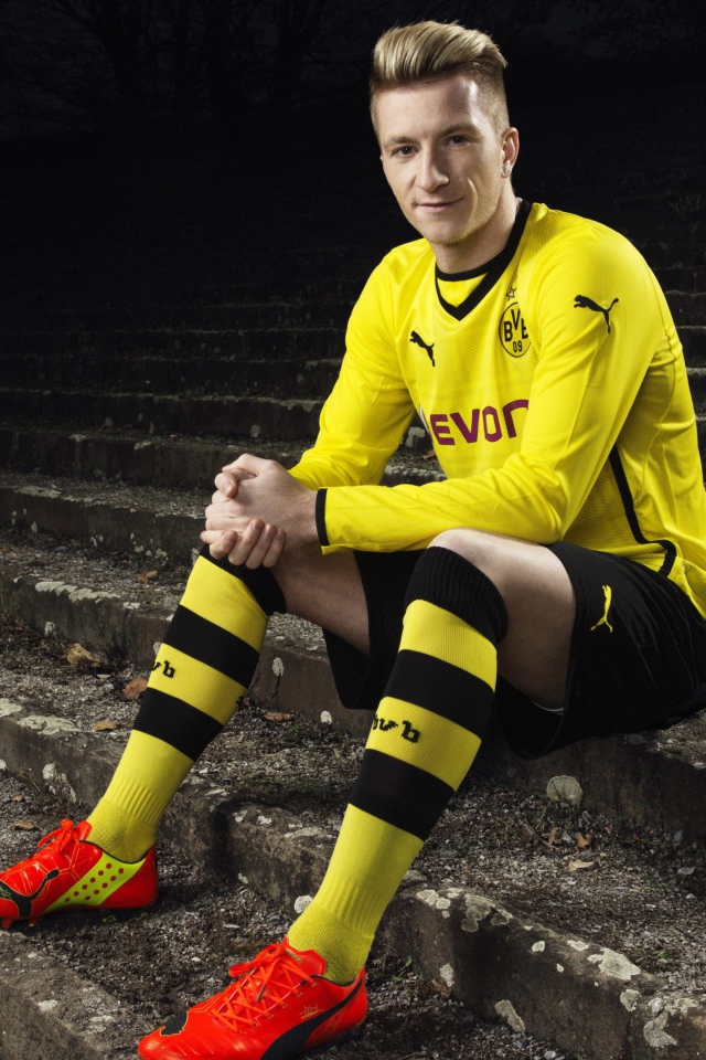 Немецкий футболист Марко Ройс сидит на ступеньках 