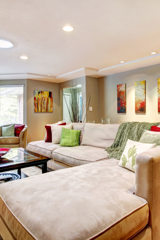 Большой диван в интерьере гостинной в пастельных тонах