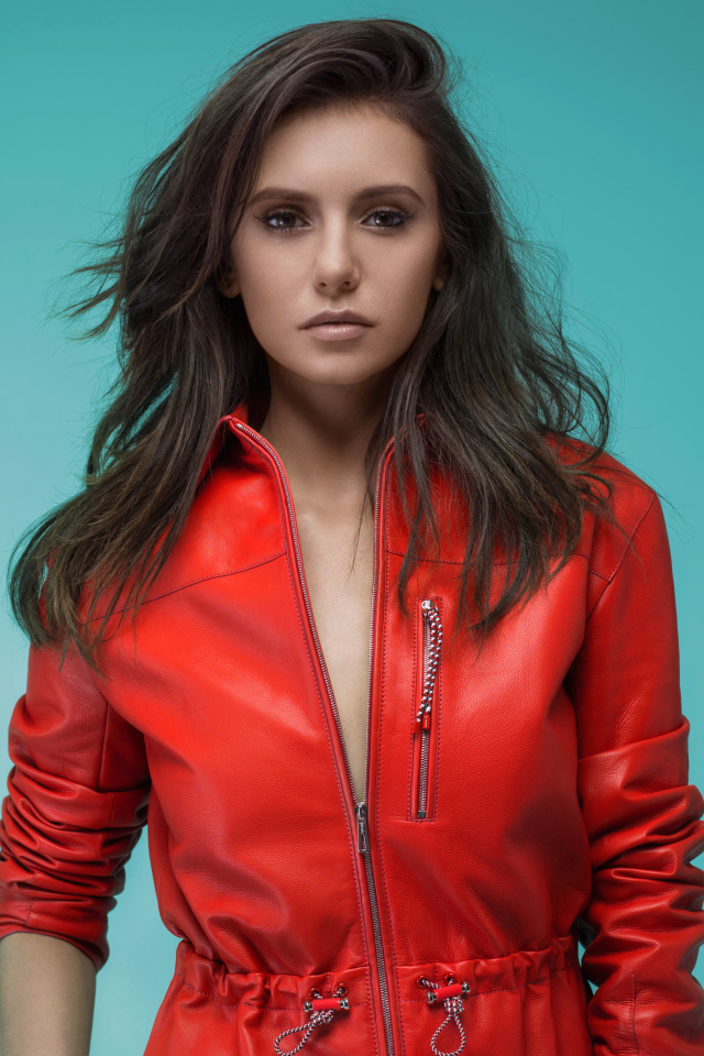 Популярная актриса Нина Добрев в красной куртке на зеленом фоне
