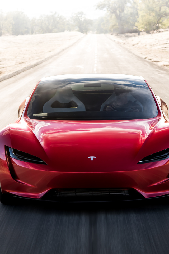 Красный автомобиль Tesla Roadster на трассе, вид спереди