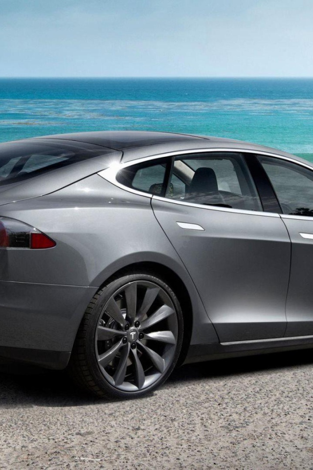 Электрокар Tesla Model S на фоне океана   