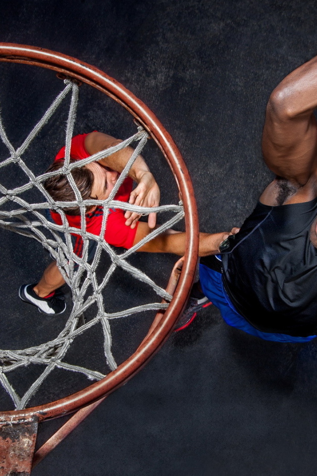 Баскетболист забрасывает мяч в кольцо 