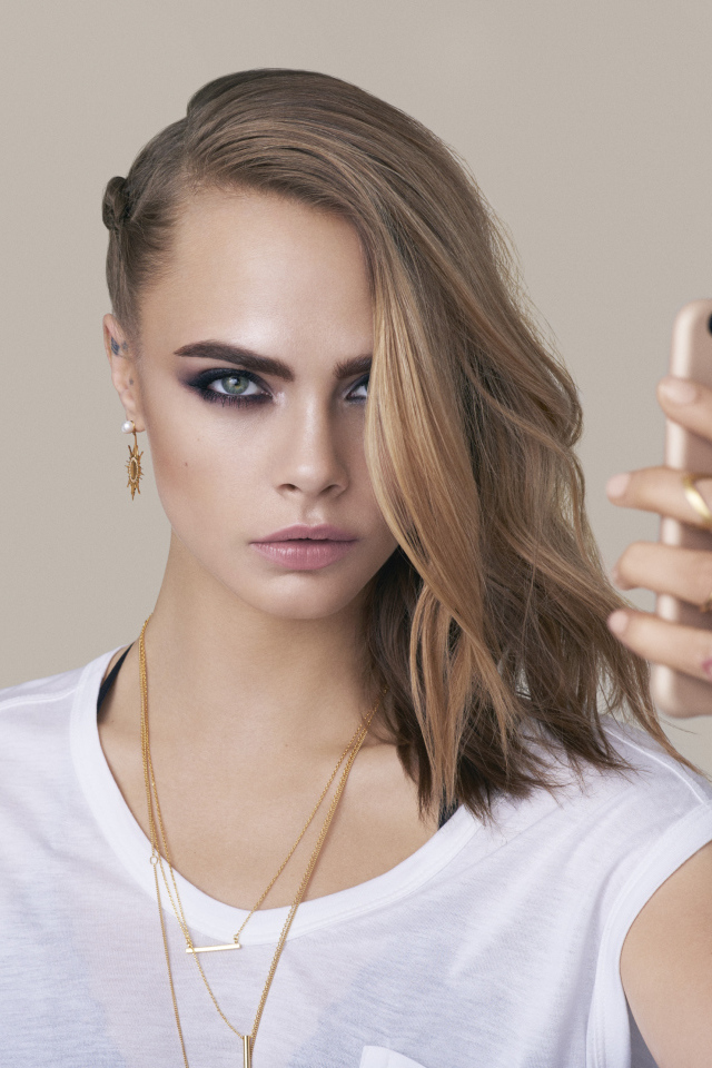 Молодая актриса Кара Делевинь с телефоном в руках