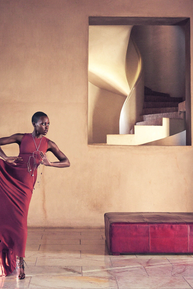 Молодая актриса Люпита Нионго танцует в красном платье