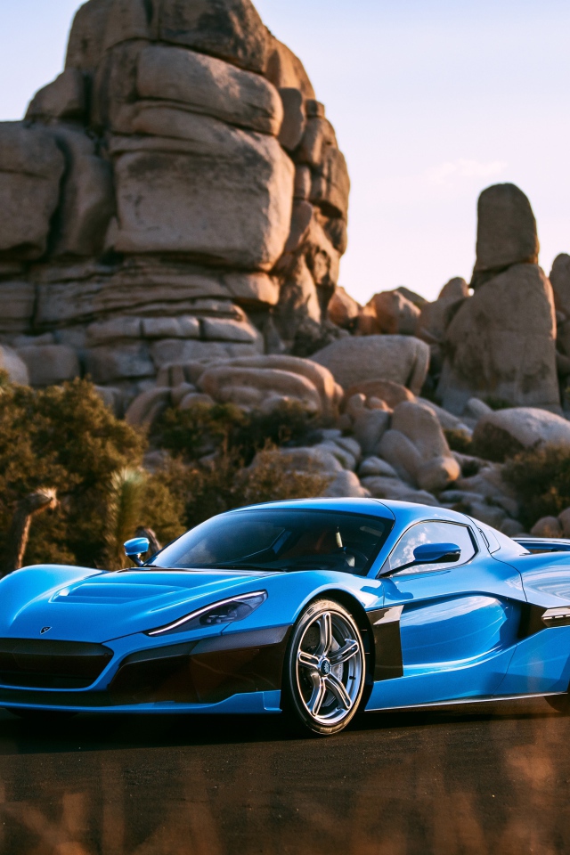 Blue sports car Rimac C_Two against the background of mountains