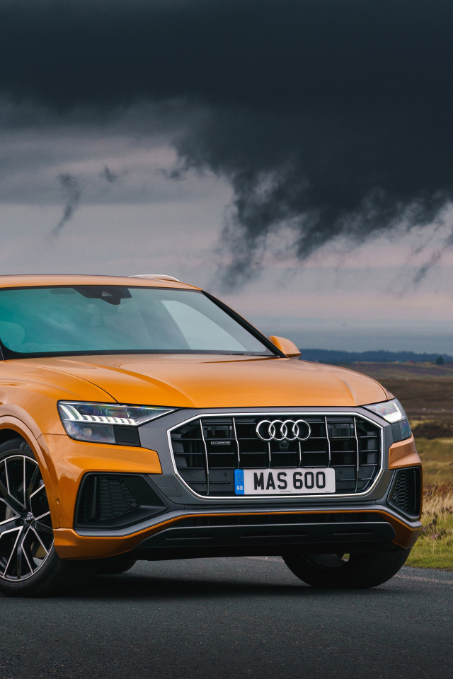 Orange car Audi Q8, 2018 on the background of a stormy sky