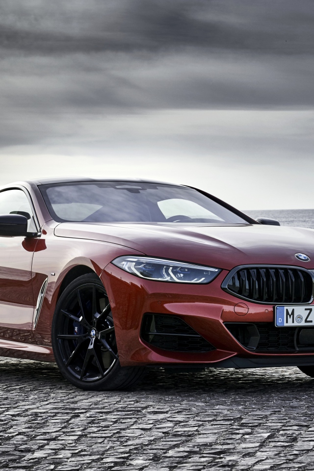 Красный автомобиль BMW 8 Series на фоне моря