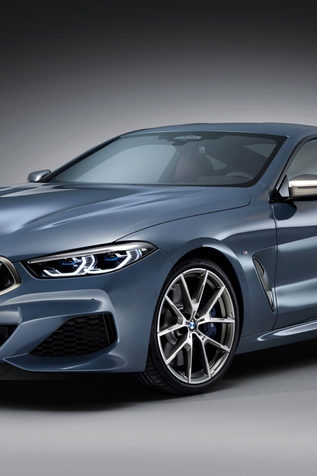 Серебристый автомобиль BMW M850i, 2018 на сером фоне