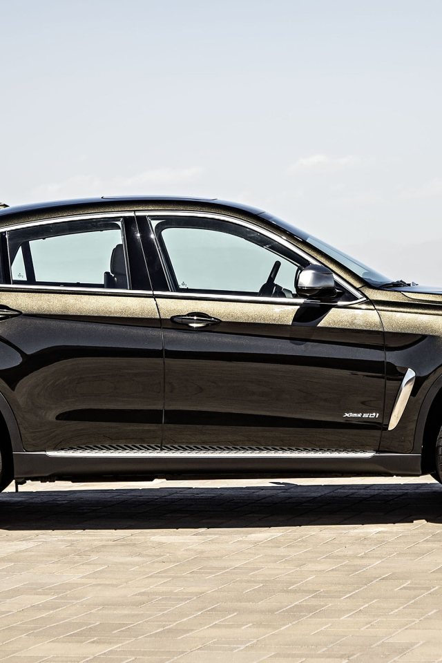 Черный автомобиль BMW X6, 2018 года вид сбоку