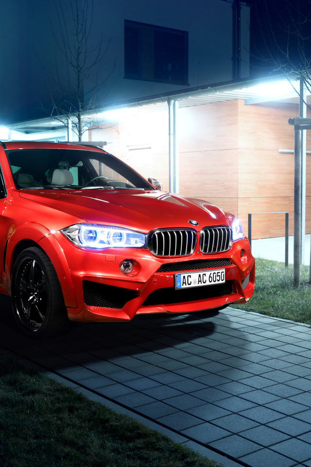 Красный автомобиль BMW X6 на тротуаре