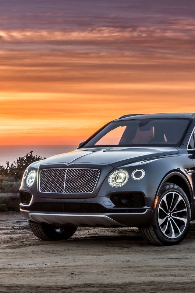 Черный стильный стильный автомобиль Bentley на фоне заката 