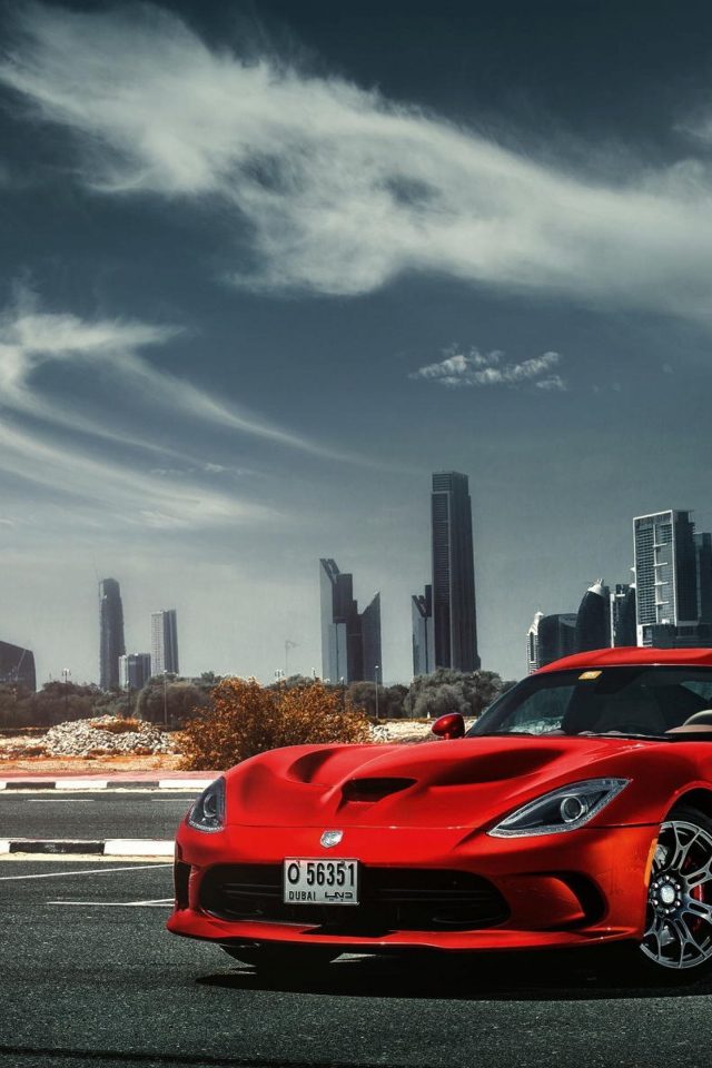 Красный спортивный автомобиль Dodge Viper SRT 2018 года на фоне города