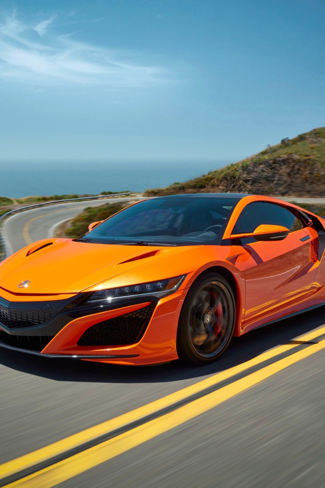 Оранжевый автомобиль Honda NSX на трассе под голубым небом