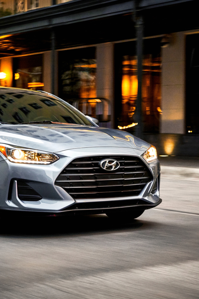 Silver car Hyundai Veloster, 2019 with headlights on
