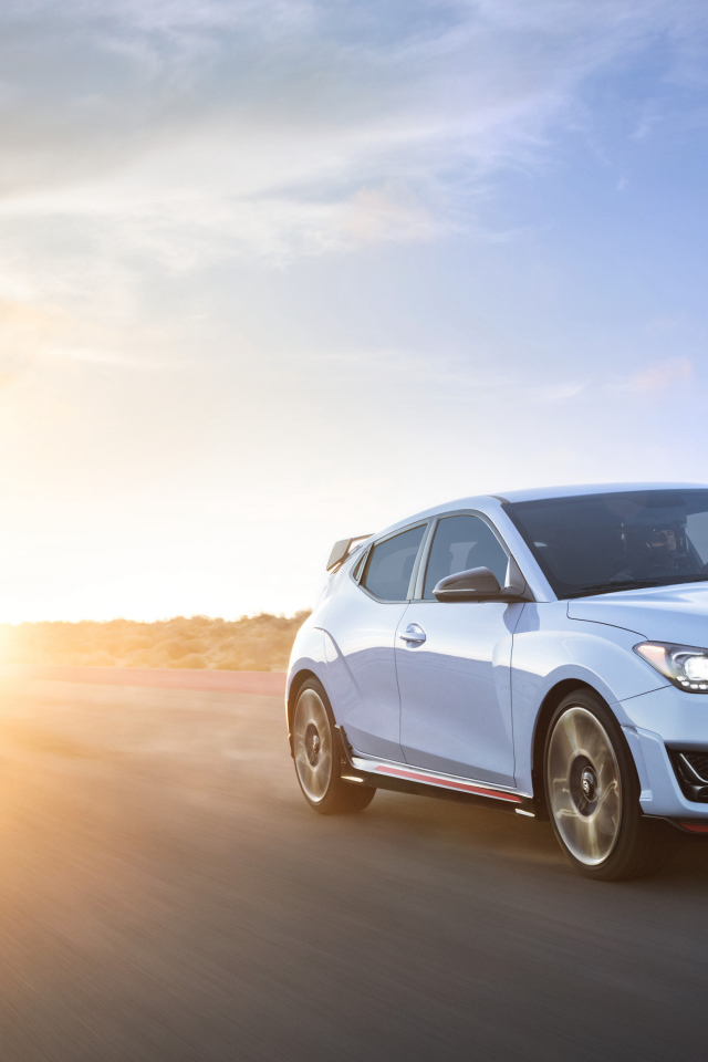 White car Hyundai Veloster N 2, 2019 against the background of the sun
