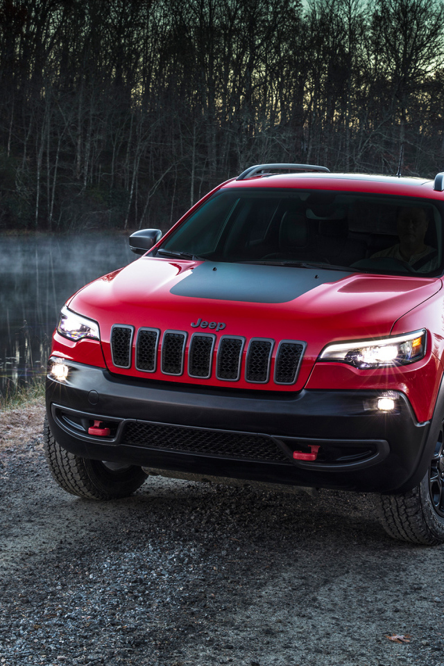 Красный автомобиль Jeep Cherokee Trailhawk, 2019 на дороге у реки