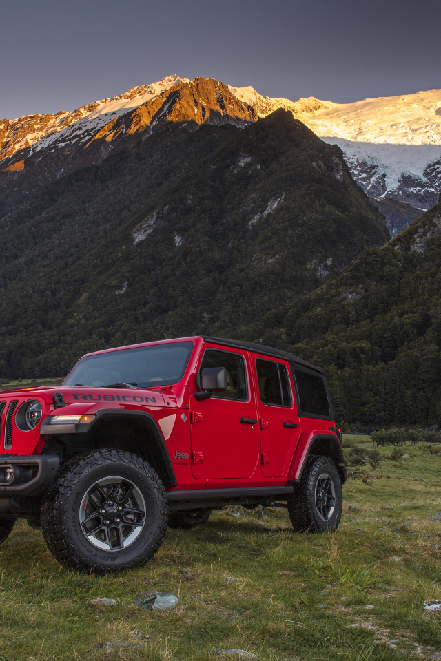 Красный автомобиль Jeep Wrangler на фоне гор