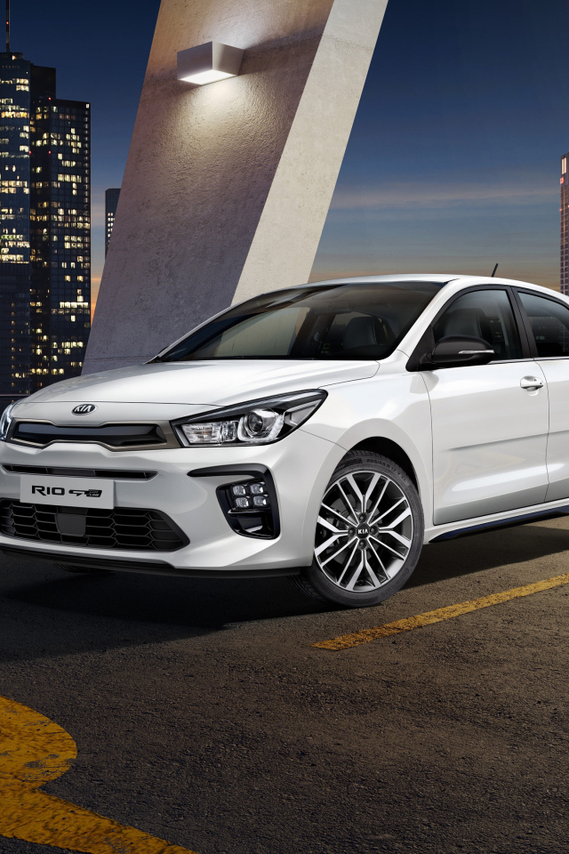 Белый автомобиль хэтчбек Kia Rio GT Line, 2018 на фоне ночного города