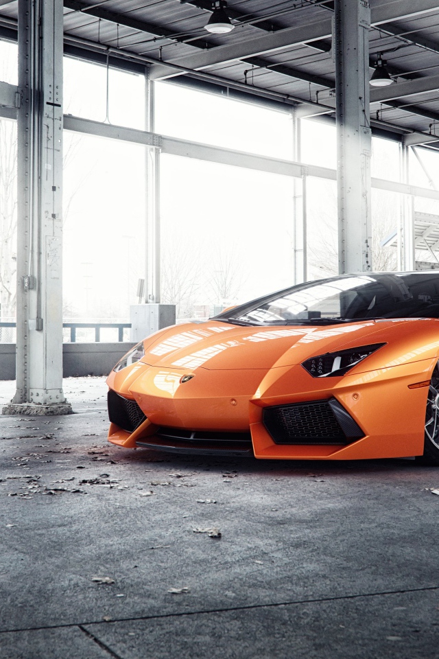 Оранжевый автомобиль Lamborghini Aventador под мостом