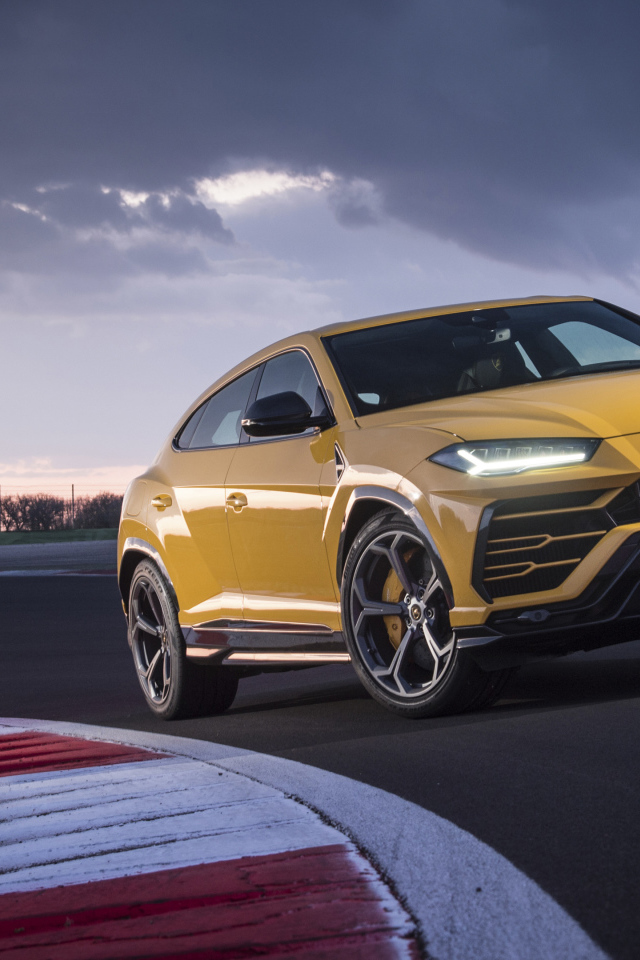Желтый внедорожник Lamborghini Urus  едет по дороге