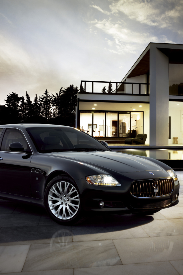 Черный автомобиль  Maserati Quattroporte у большого дома