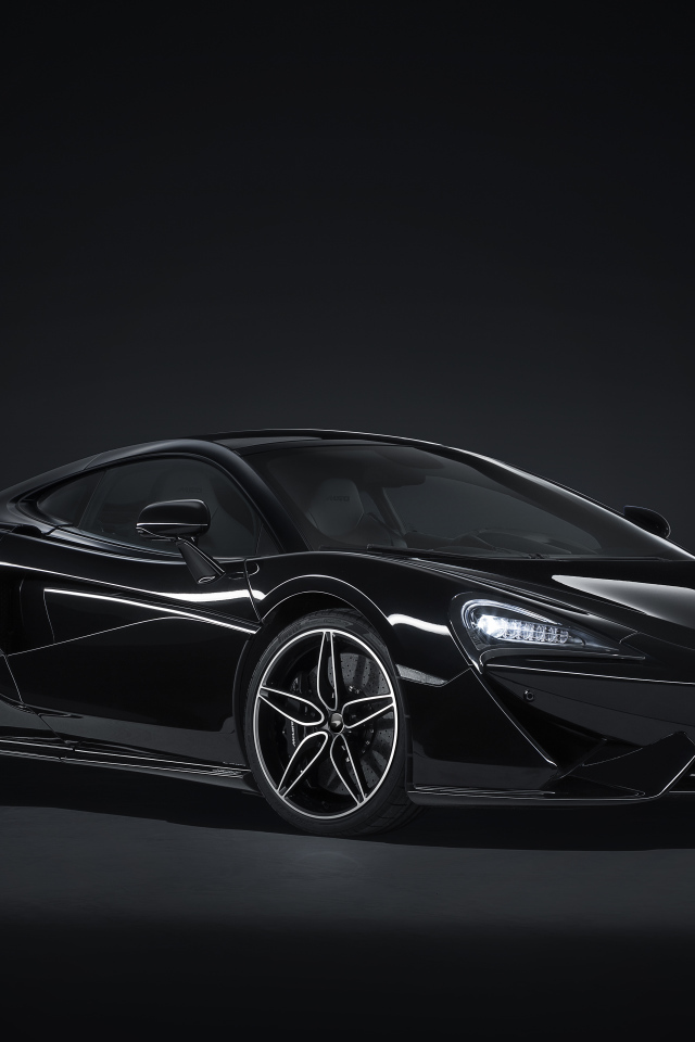 Черный спортивный автомобиль McLaren 570GT на сером фоне