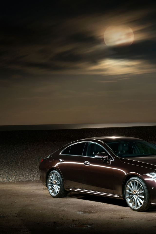 Коричневый автомобиль Mercedes Benz CLS 400 D AMG 2018 года на фоне луны