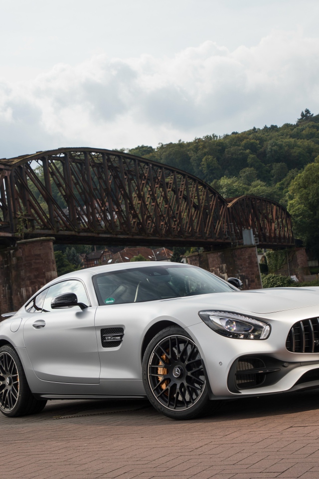 Серебристый автомобиль Mercedes-AMG GT на фоне моста