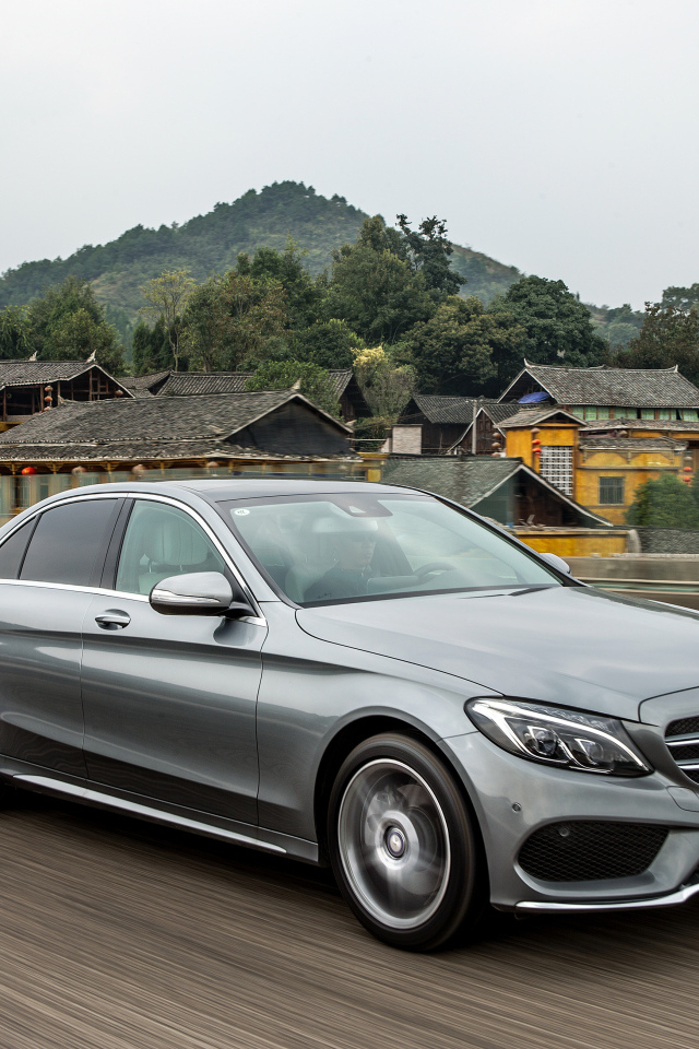 Серебристый автомобиль Mercedes-Benz C-Class на трассе