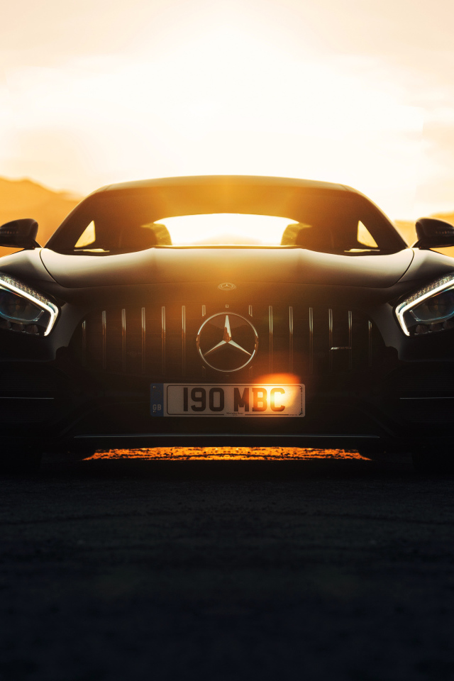 Стильный черный автомобиль Mercedes-AMG GT C на фоне заката