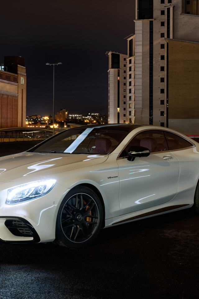 Белый автомобиль Mercedes AMG S 63 4MATIC Coupe, 2018 года на фоне города