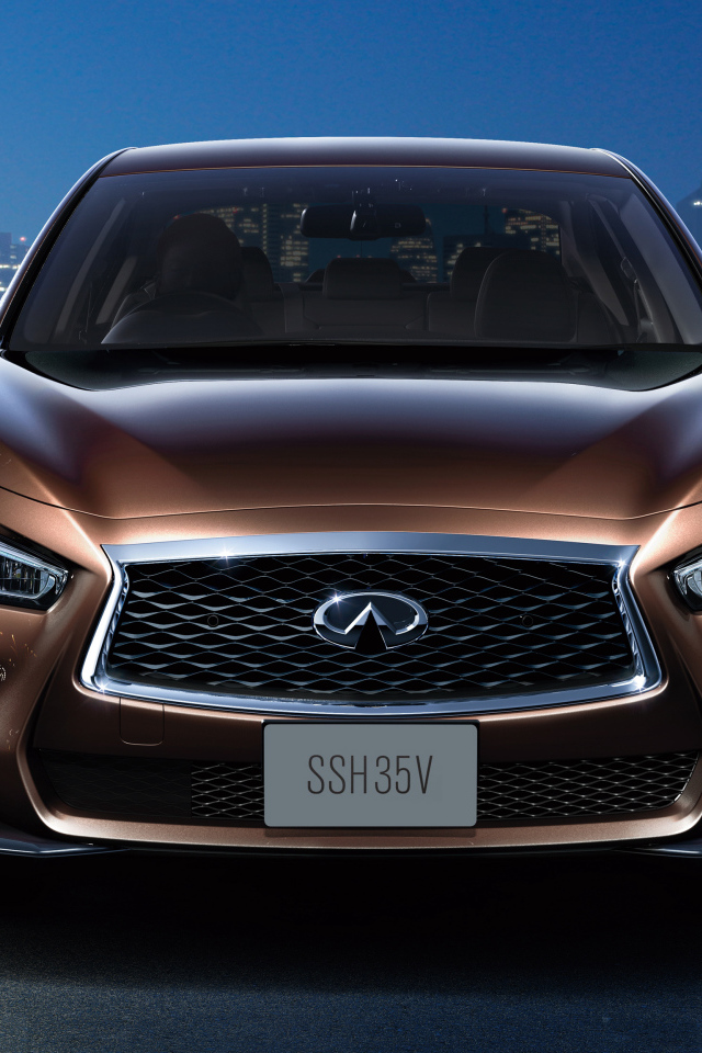 Коричневый автомобиль Nissan Skyline Hybrid, 2018 на фоне ночного города