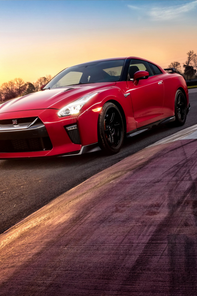 Красный автомобиль Nissan GT-R 2018 года на трассе на закате