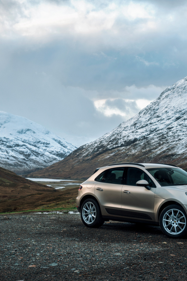 Внедорожник Porsche Macan на фоне заснеженных гор 