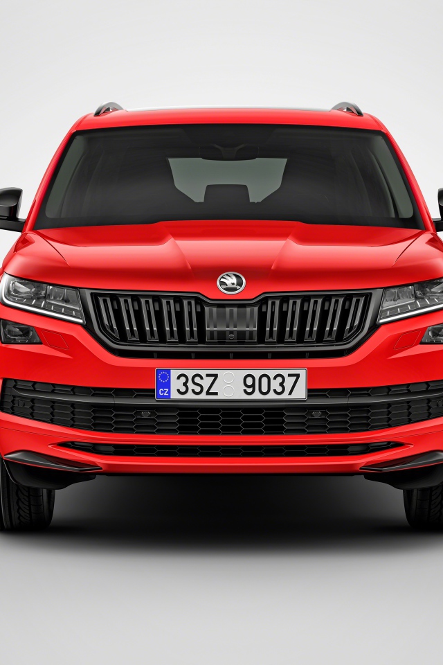 Красный автомобиль Skoda Kodiaq на сером фоне